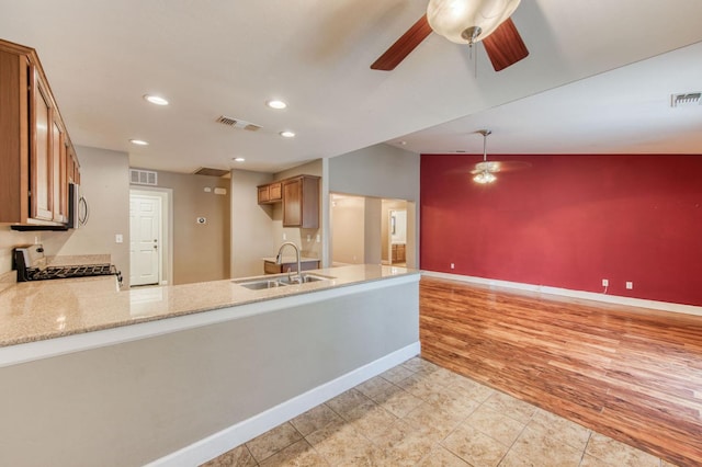 564 S Duke Ave, Fresno, CA 93727 - kitchen featuring a ceiling fan, stove, stainless steel microwave, brown cabinetry, and a peninsula