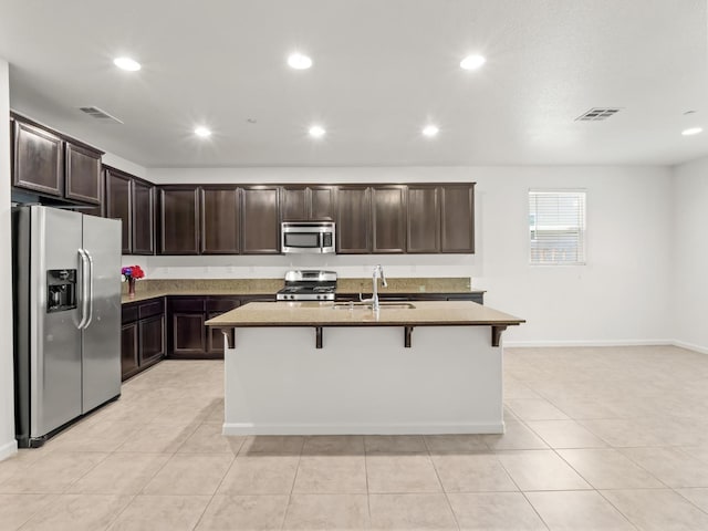 3807 N Pearwood Ave, Fresno, CA 93727 - kitchen featuring stainless steel appliances, recessed lighting, dark brown cabinets, a kitchen breakfast bar, and light tile patterned floors