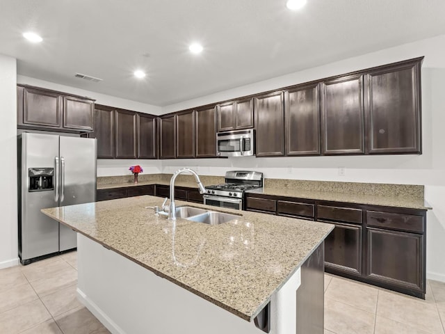 3807 N Pearwood Ave, Fresno, CA 93727 - kitchen with appliances with stainless steel finishes, light tile patterned floors, dark brown cabinets, light stone countertops, and recessed lighting
