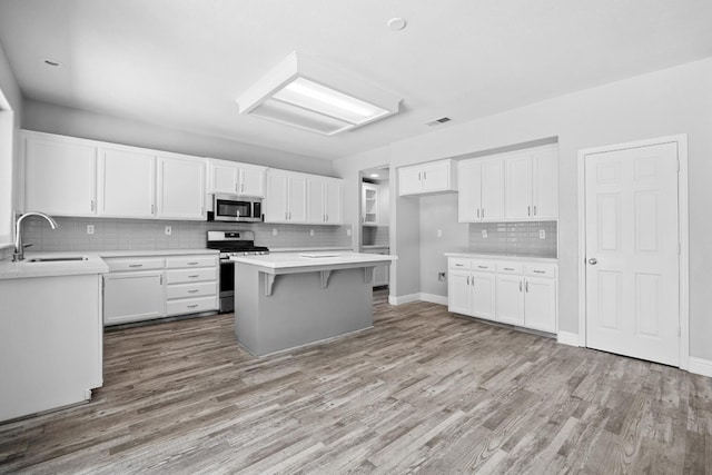 2720 San Jose Ave, Clovis, CA 93611 - kitchen with appliances with stainless steel finishes, tasteful backsplash, light wood finished floors, and white cabinets