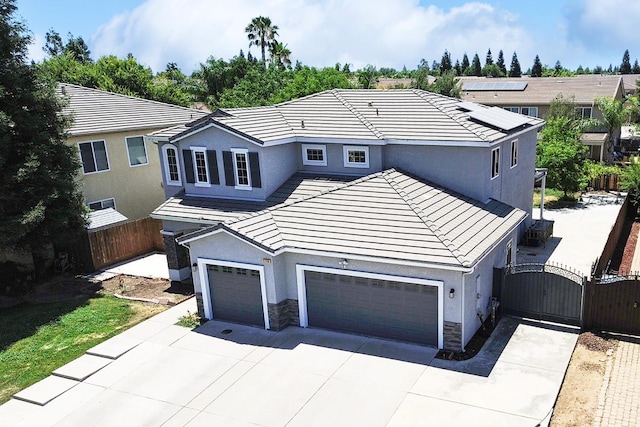 2720 San Jose Ave, Clovis, CA 93611 - rear view of house with a gate, stone siding, concrete driveway, and stucco siding