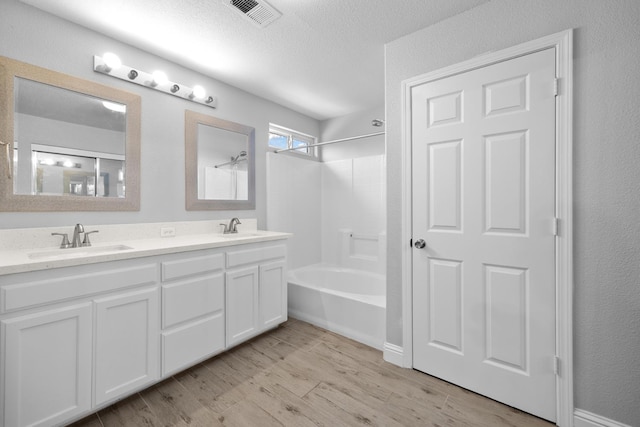 2720 San Jose Ave, Clovis, CA 93611 - bathroom featuring double vanity, shower / washtub combination, wood finished floors, and a textured ceiling