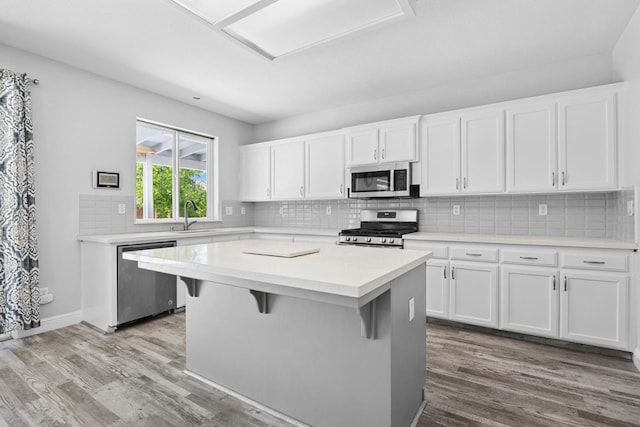 2720 San Jose Ave, Clovis, CA 93611 - kitchen featuring stainless steel appliances, light wood-style floors, a center island, and white cabinets
