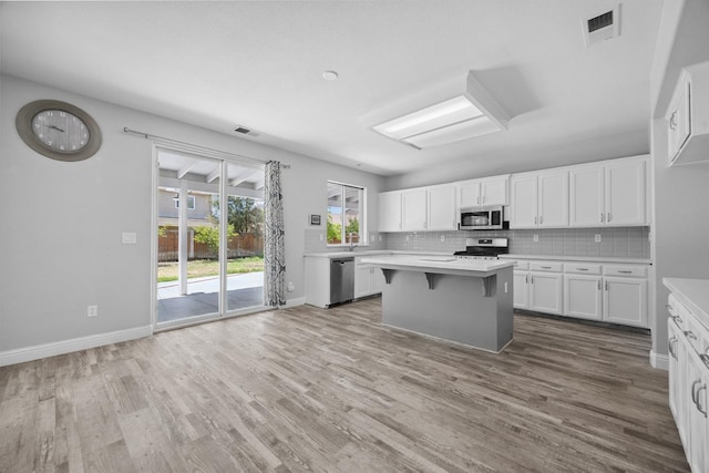 2720 San Jose Ave, Clovis, CA 93611 - kitchen featuring appliances with stainless steel finishes, light countertops, white cabinetry, wood finished floors, and backsplash