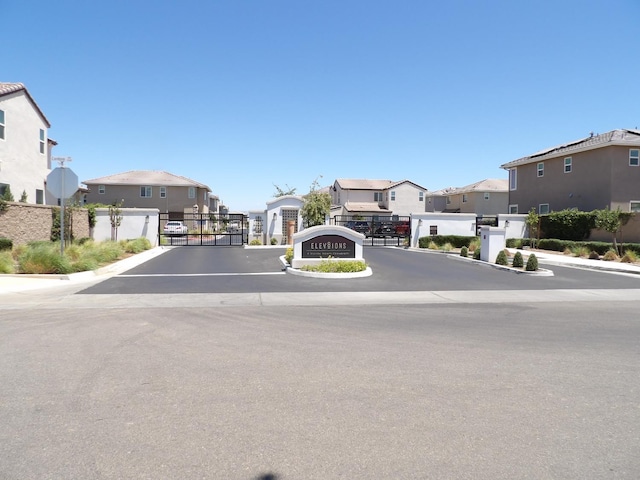 3725 Graystoke Way, Clovis, CA 93619 - view of asphalt road with a residential view, a gate, curbs, a gated entry, and traffic signs