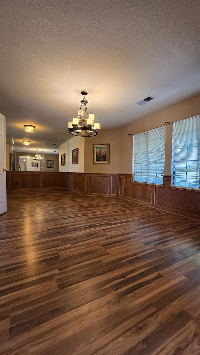 1386 E El Paso Ave, Fresno, CA 93720 - unfurnished living room with dark wood finished floors, a chandelier, a wainscoted wall, and a textured ceiling
