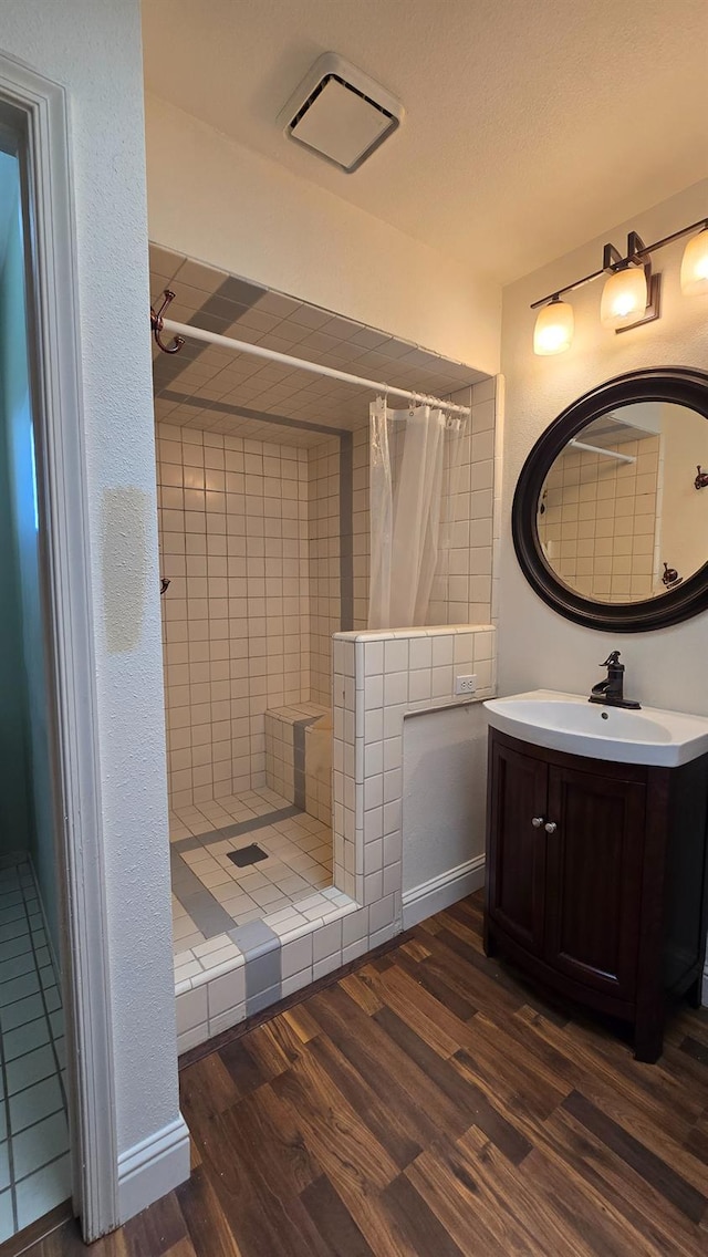 1386 E El Paso Ave, Fresno, CA 93720 - bathroom with a tile shower, wood finished floors, vanity, and a fireplace