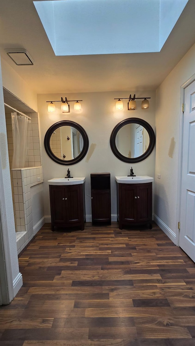 1386 E El Paso Ave, Fresno, CA 93720 - bathroom with a skylight, wood finished floors, and two vanities