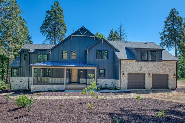 42732 Granite Cir, Shaver Lake, CA 93664 - modern inspired farmhouse featuring covered porch, stone siding, an attached garage, a standing seam roof, and roof with shingles