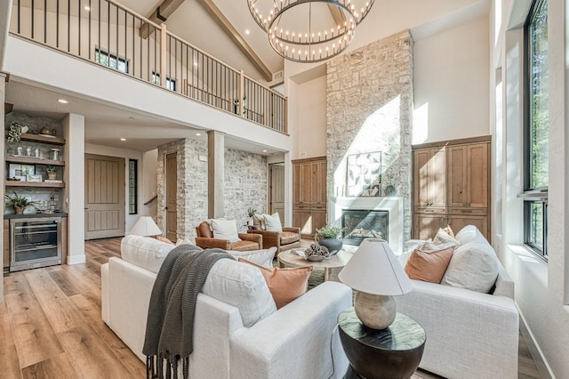 42732 Granite Cir, Shaver Lake, CA 93664 - living area featuring wine cooler, high vaulted ceiling, a large fireplace, light wood-style floors, and a chandelier