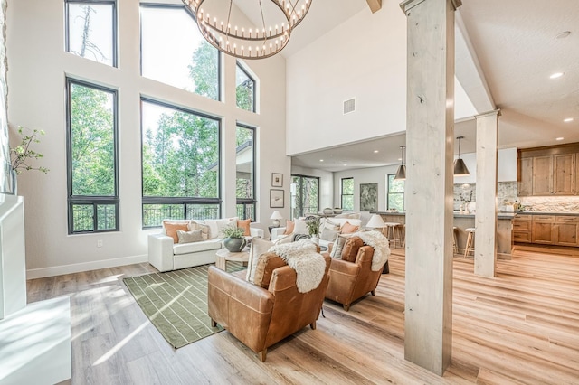 42732 Granite Cir, Shaver Lake, CA 93664 - living room featuring light wood-style floors, recessed lighting, a high ceiling, a chandelier, and ornate columns