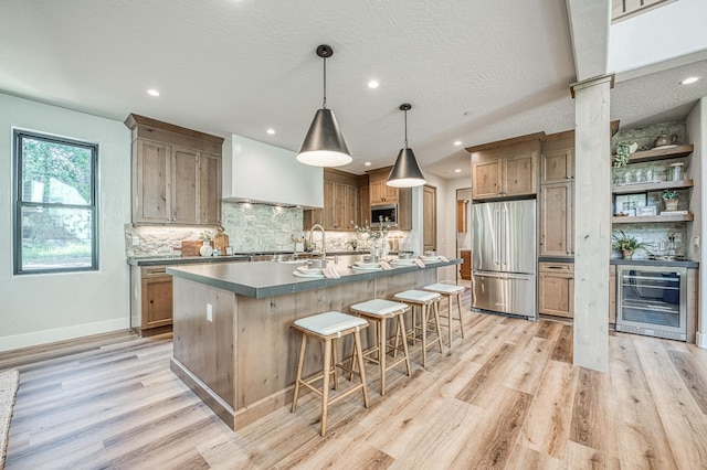 42732 Granite Cir, Shaver Lake, CA 93664 - kitchen featuring stainless steel appliances, beverage cooler, wall chimney range hood, light wood-type flooring, and recessed lighting