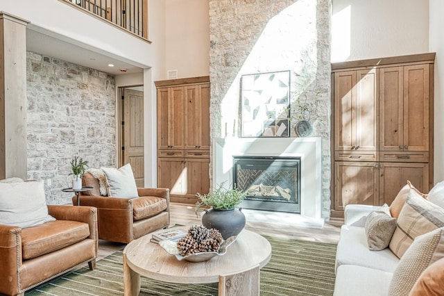 42732 Granite Cir, Shaver Lake, CA 93664 - living area with a high ceiling, a glass covered fireplace, and light wood-type flooring