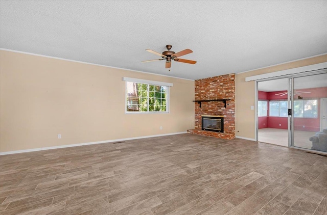 1649 W Menlo, Fresno, CA 93711 - unfurnished living room with ceiling fan, wood finished floors, a brick fireplace, a textured ceiling, and crown molding
