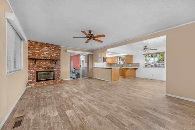 1649 W Menlo, Fresno, CA 93711 - unfurnished living room featuring light wood-style flooring, a textured ceiling, a ceiling fan, and a fireplace