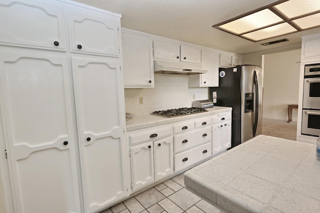 110 N Terry Ave, Clovis, CA 93612 - kitchen featuring stainless steel appliances, white cabinetry, under cabinet range hood, and decorative backsplash