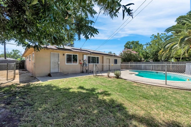 3635 N Hughes, Fresno, CA 93705 - rear view of house featuring a fenced backyard, stucco siding, roof mounted solar panels, and a patio