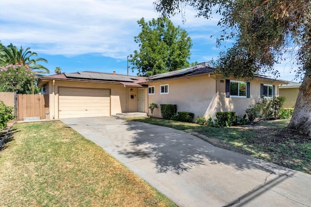 3635 N Hughes, Fresno, CA 93705 - ranch-style house featuring stucco siding, an attached garage, concrete driveway, and solar panels
