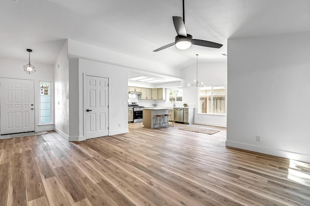 1033 Cypress Ct, Madera, CA 93637 - unfurnished living room with vaulted ceiling, light wood-style flooring, a ceiling fan, and a chandelier