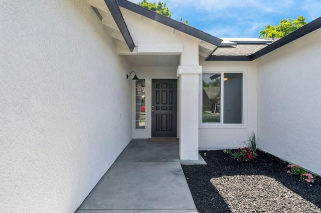 1033 Cypress Ct, Madera, CA 93637 - property entrance with stucco siding and roof mounted solar panels