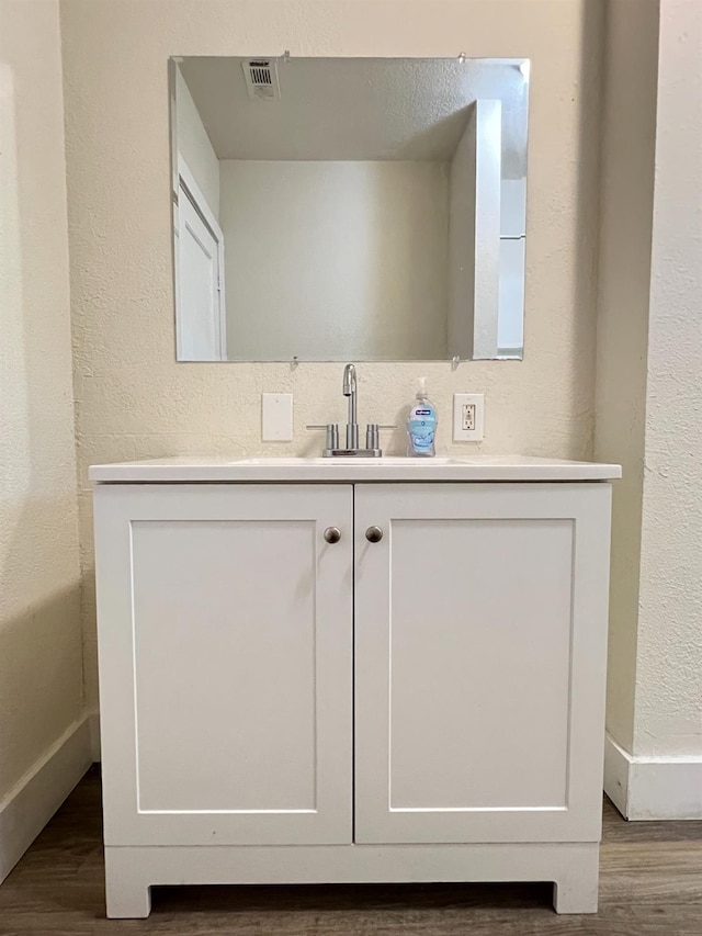 2405 E White Ave, Fresno, CA 93701 - bathroom featuring wood finished floors, vanity, and a textured wall