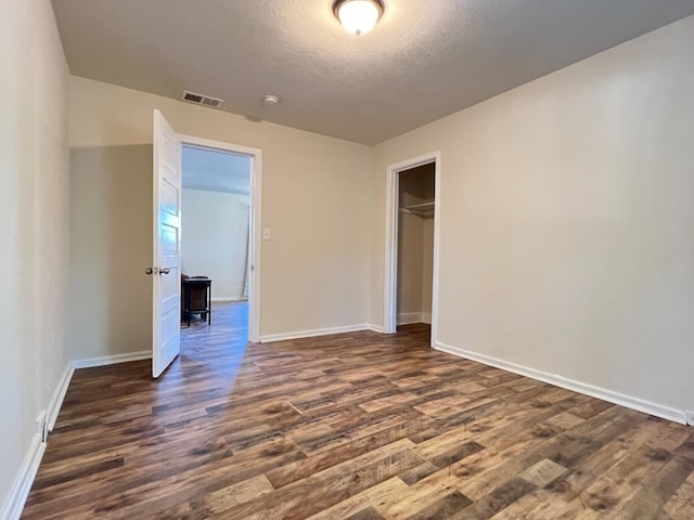 2405 E White Ave, Fresno, CA 93701 - unfurnished bedroom with dark wood-style flooring, a textured ceiling, and a closet
