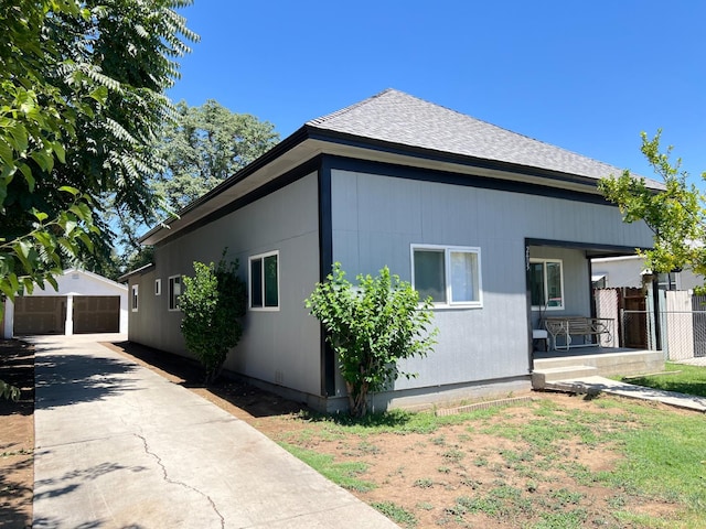 2405 E White Ave, Fresno, CA 93701 - view of property exterior featuring an outbuilding, a detached garage, a porch, and roof with shingles