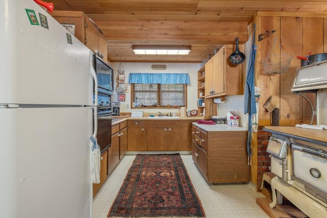 48675 Todd Eymann Rd, Miramonte, CA 93641 - kitchen featuring freestanding refrigerator, brown cabinets, wooden ceiling, light countertops, and light floors