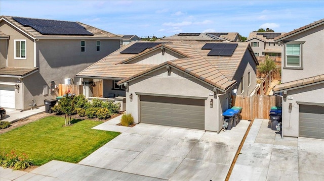 627 S Kandarian Ave, Fowler, CA 93625 - view of front of house with a tile roof, concrete driveway, roof mounted solar panels, and stucco siding
