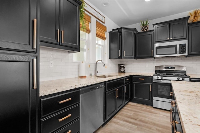 627 S Kandarian Ave, Fowler, CA 93625 - kitchen with appliances with stainless steel finishes, dark cabinetry, tasteful backsplash, and light stone counters