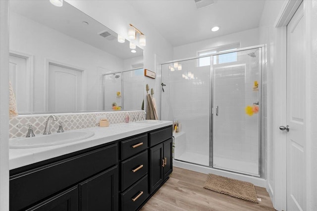 627 S Kandarian Ave, Fowler, CA 93625 - bathroom with double vanity, a stall shower, decorative backsplash, and wood finished floors