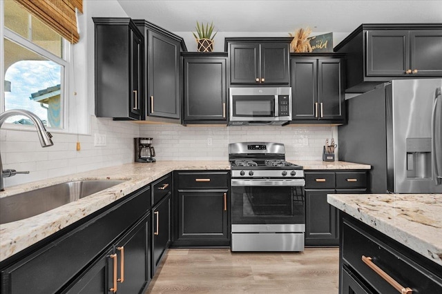 627 S Kandarian Ave, Fowler, CA 93625 - kitchen featuring appliances with stainless steel finishes, dark cabinets, and light stone counters
