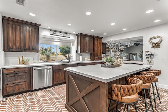 3377 N Bethel Ave, Sanger, CA 93657 - kitchen featuring stainless steel dishwasher, a breakfast bar, light countertops, recessed lighting, and brick patterned floors