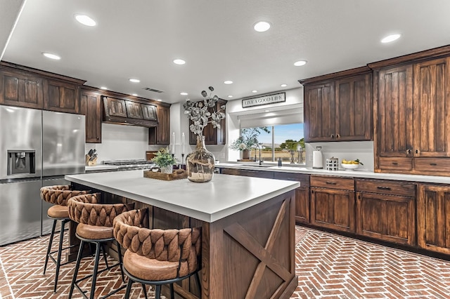 3377 N Bethel Ave, Sanger, CA 93657 - kitchen with appliances with stainless steel finishes, brick floors, recessed lighting, a breakfast bar, and light countertops