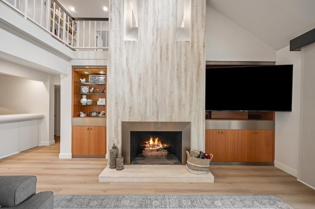 2734 W Bluff Ave, Fresno, CA 93711 - living area with a lit fireplace, high vaulted ceiling, and wood finished floors