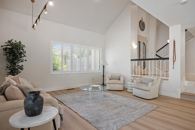 2734 W Bluff Ave, Fresno, CA 93711 - living room with stairway, wood finished floors, high vaulted ceiling, and track lighting