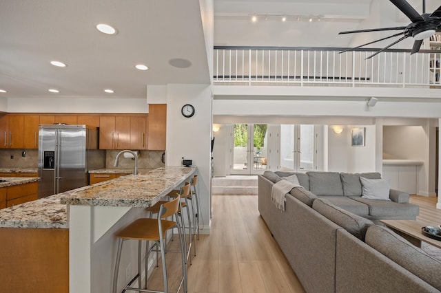 2734 W Bluff Ave, Fresno, CA 93711 - kitchen with high end refrigerator, brown cabinetry, ceiling fan, open floor plan, and a peninsula