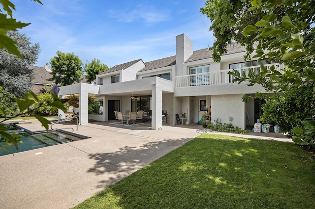 2734 W Bluff Ave, Fresno, CA 93711 - back of property featuring stucco siding, a balcony, a patio area, a yard, and a chimney