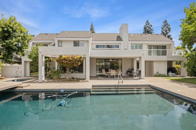 2734 W Bluff Ave, Fresno, CA 93711 - rear view of property with a balcony, stucco siding, a patio, and an outdoor pool