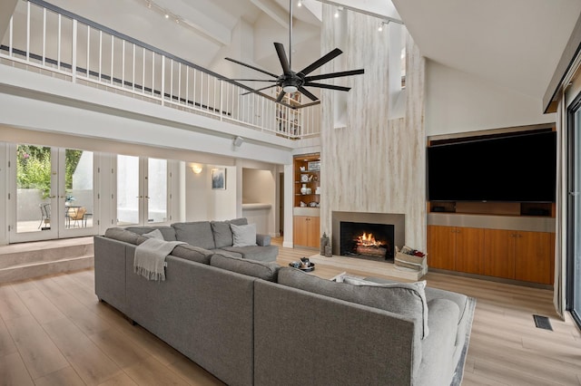2734 W Bluff Ave, Fresno, CA 93711 - living area featuring high vaulted ceiling, a large fireplace, light wood-style flooring, french doors, and a ceiling fan