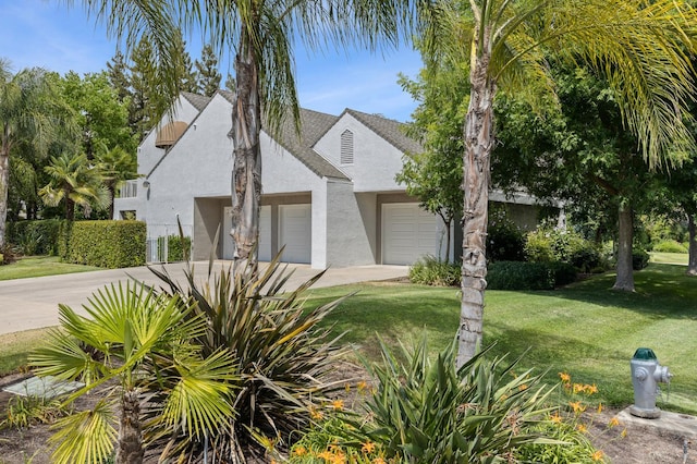 2734 W Bluff Ave, Fresno, CA 93711 - view of front of home with stucco siding, driveway, a front yard, and a garage