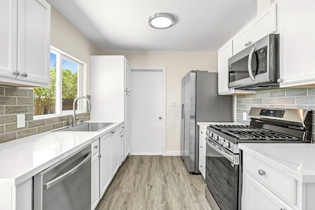 4729 E Cornell Ave, Fresno, CA 93703 - kitchen featuring stainless steel appliances, light wood-style floors, tasteful backsplash, light stone counters, and white cabinetry