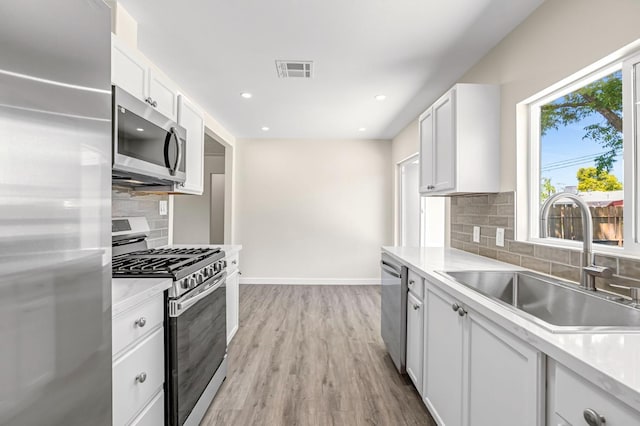4729 E Cornell Ave, Fresno, CA 93703 - kitchen featuring stainless steel appliances, decorative backsplash, white cabinetry, light countertops, and recessed lighting