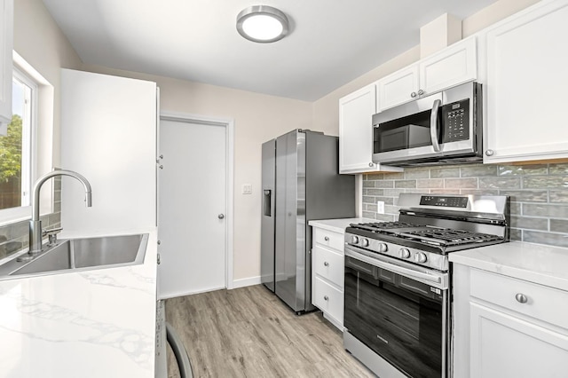 4729 E Cornell Ave, Fresno, CA 93703 - kitchen with appliances with stainless steel finishes, light wood finished floors, backsplash, white cabinets, and light stone countertops