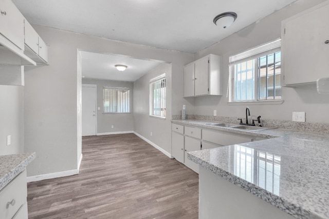 3137 E Townsend Ave, Fresno, CA 93702 - kitchen with light countertops, healthy amount of natural light, light wood-type flooring, and white cabinetry