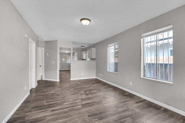 3137 E Townsend Ave, Fresno, CA 93702 - unfurnished living room featuring a textured ceiling and dark wood finished floors