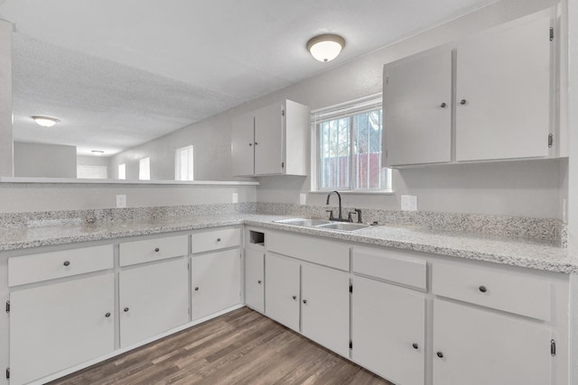 3137 E Townsend Ave, Fresno, CA 93702 - kitchen featuring wood finished floors, light countertops, white cabinets, and a textured ceiling