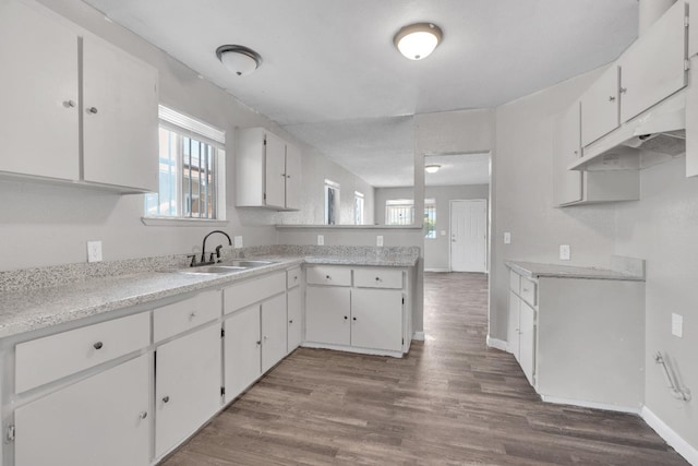 3137 E Townsend Ave, Fresno, CA 93702 - kitchen with a peninsula, light countertops, dark wood-style floors, and white cabinetry