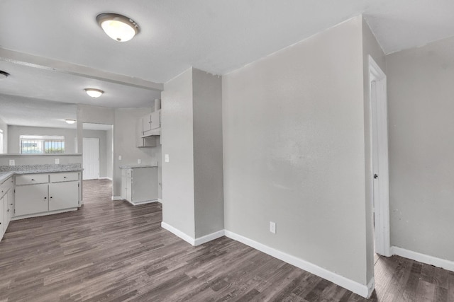 3137 E Townsend Ave, Fresno, CA 93702 - unfurnished living room with baseboards and dark wood-type flooring