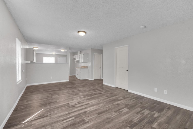 3137 E Townsend Ave, Fresno, CA 93702 - unfurnished living room with a textured ceiling and dark wood-style floors